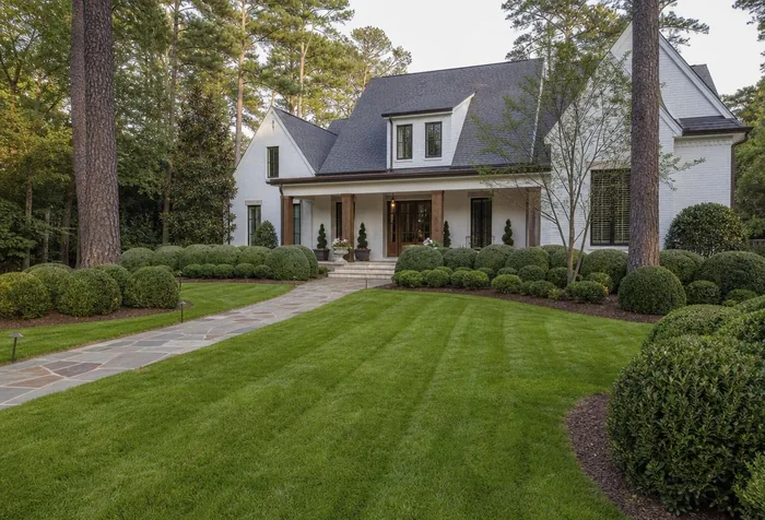 Completed front yard landscape with striped lawn and stone walkway